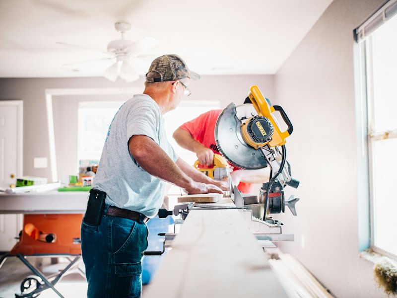 Contractor cutting trim on a miter saw