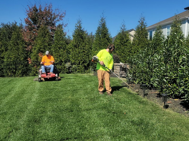 Landscaper mowing a front lawn